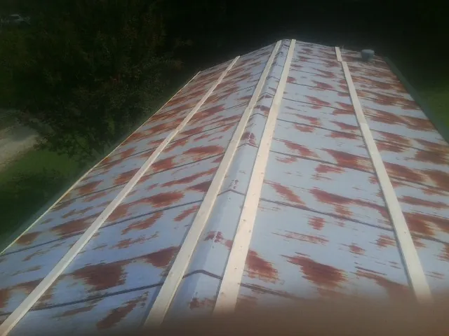 Rusted metal roof panels with new wood purlins before replacement — Storm Damage Roof Repair in Saint Stephen by Roofing Brothers